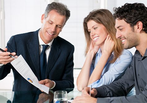 Happy young couple discussing with a financial agent their new investment